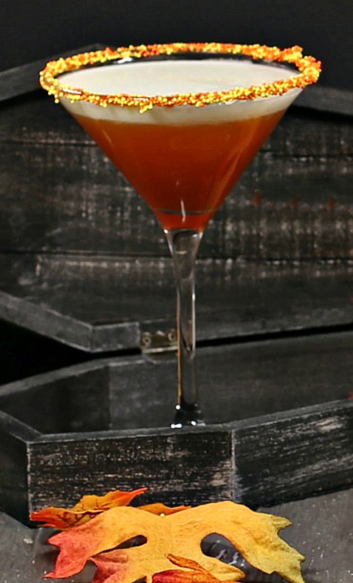 Layered candy corn martini with a candy sprinkle rim.