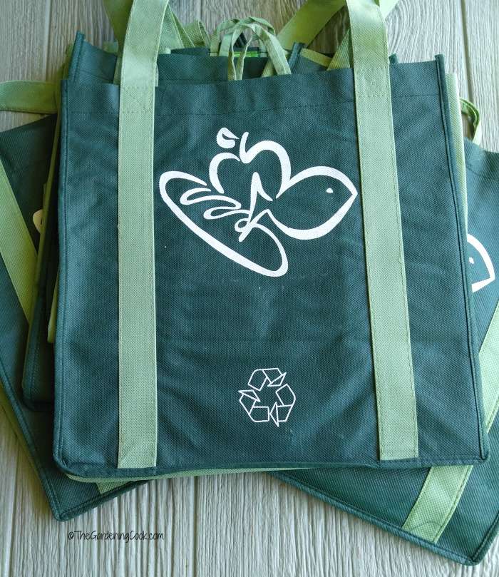 Green loth shopping bags on a wood table. 