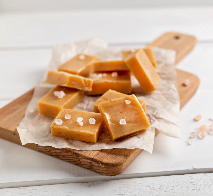 caramel fudge with seas salt on a cutting board.