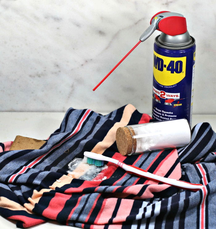 How to remove cooking oil stains from clothes. Blue striped shirt with baking soda on stain and bottle of WD-40.