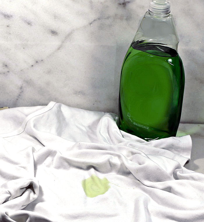Bottle of detergent and white shirt with stain