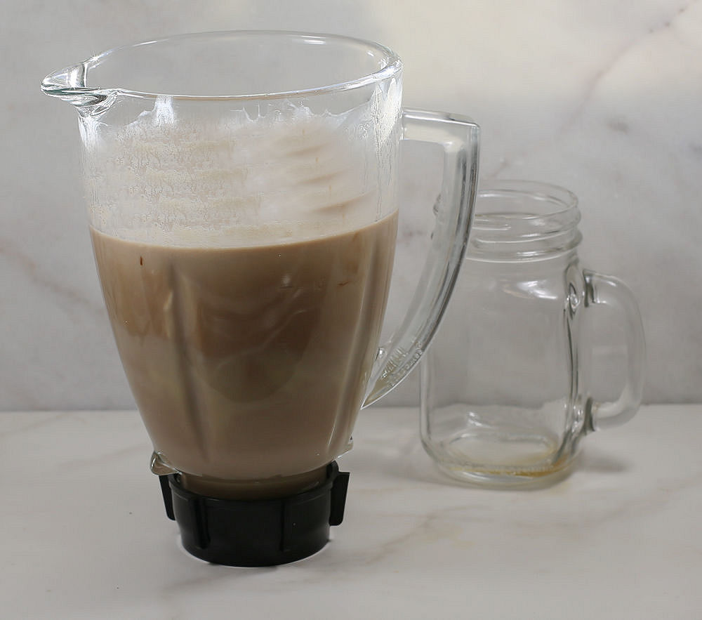 Blender full of Irish cream and a small Mason jar.