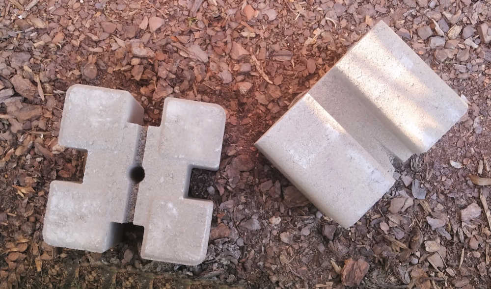Tan planter wall blocks on a mulch bed.