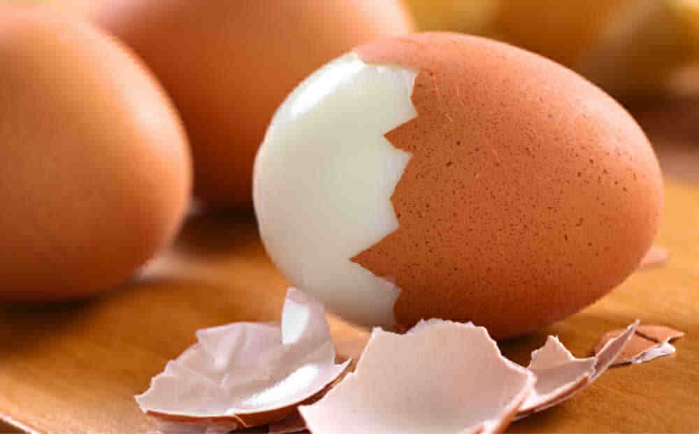 Hard boiled eggs with the shell half off the egg.