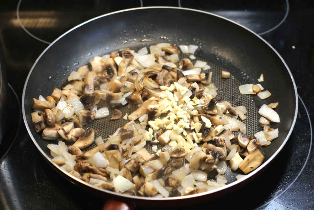Onions, garlic and mushrooms in a nonstick frying pan.