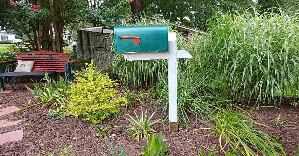 Old mailbox for garden tool storage. in a pretty garden scene.