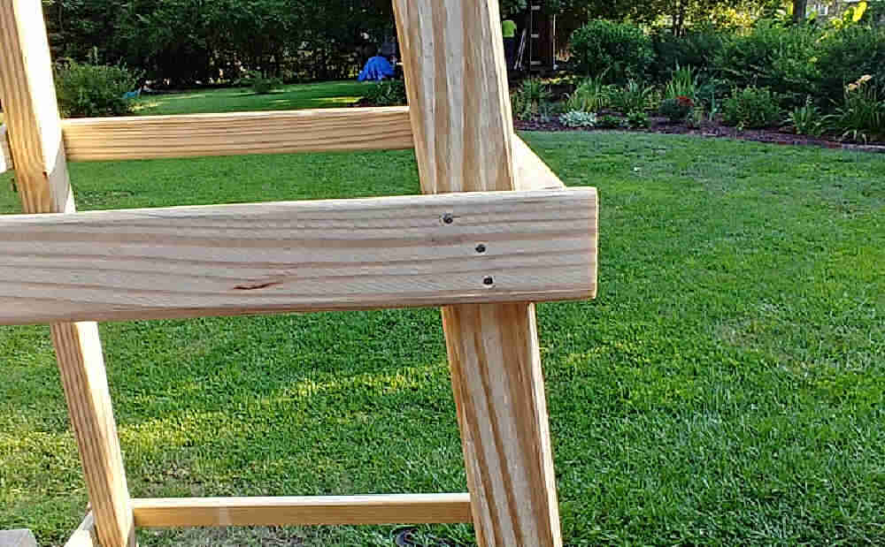 Wood of a garden tuteur with three galvanized nails.
