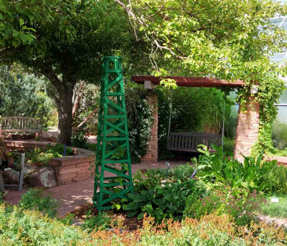 Obelisk and garden arbor in a pretty garden setting.