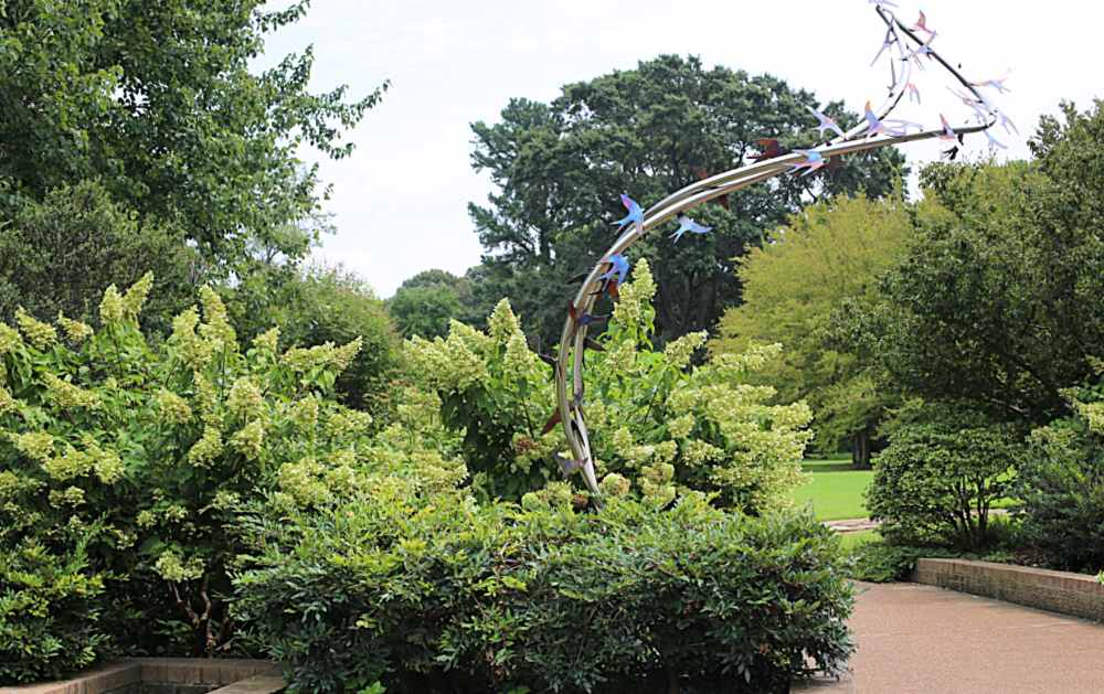 Sculpture of birds in flight in a botanical garden.