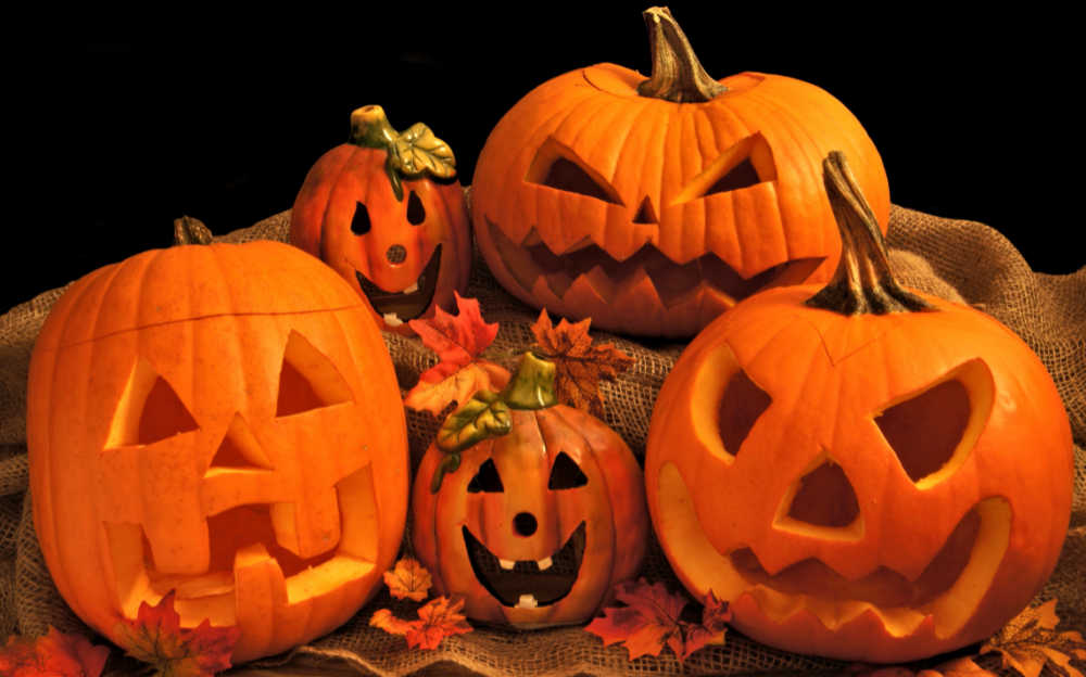 Stack of carved pumpkins with leaves.