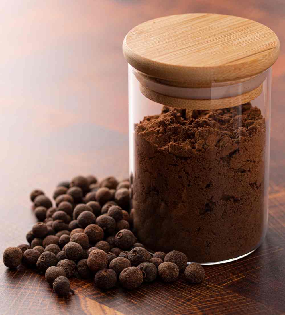 Allspice Whole and ground allspice in a jar.